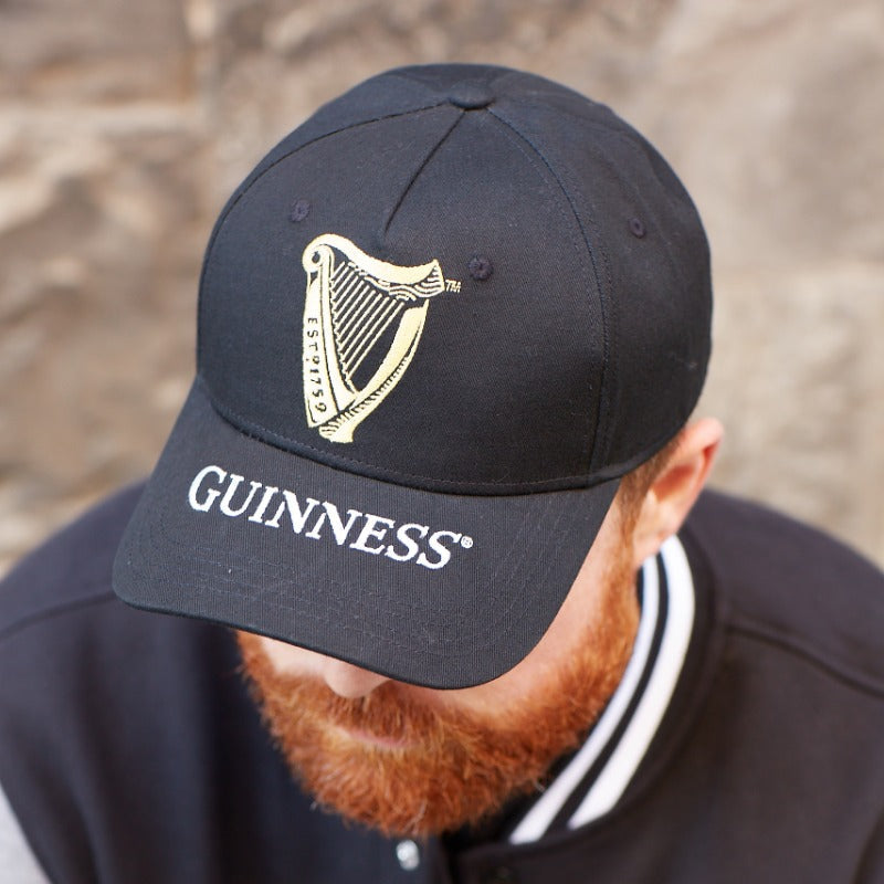 A man with a beard wearing a Guinness Harp Baseball Cap hat.