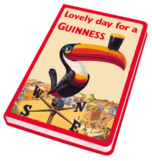 Vintage Guinness US advertisement showcasing the iconic Gilroy Toucan balancing a pint of beer on its beak, perched atop a weathervane, with the slogan "lovely day for a Guinness