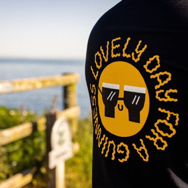 A man wearing a FATTI BURKE "LOVELY DAY FOR A GUINNESS" BLACK TEE on a lovely summer day.