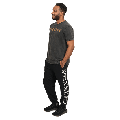 A man wearing comfortable black Guinness joggers made of organic cotton.