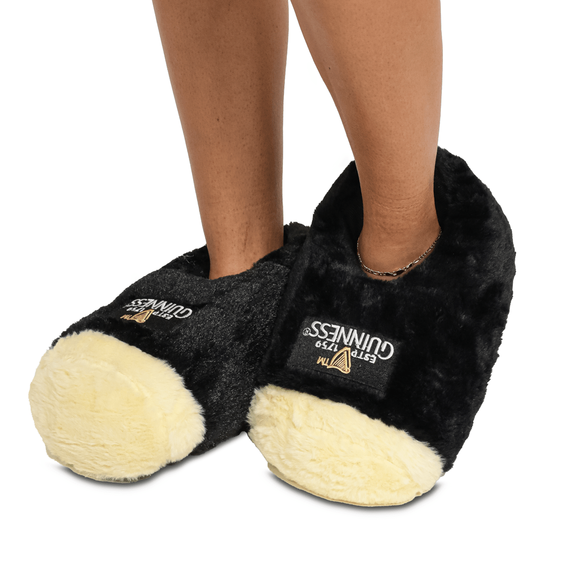 A woman wearing a pair of black and white Guinness® Pint Slippers by Guinness.