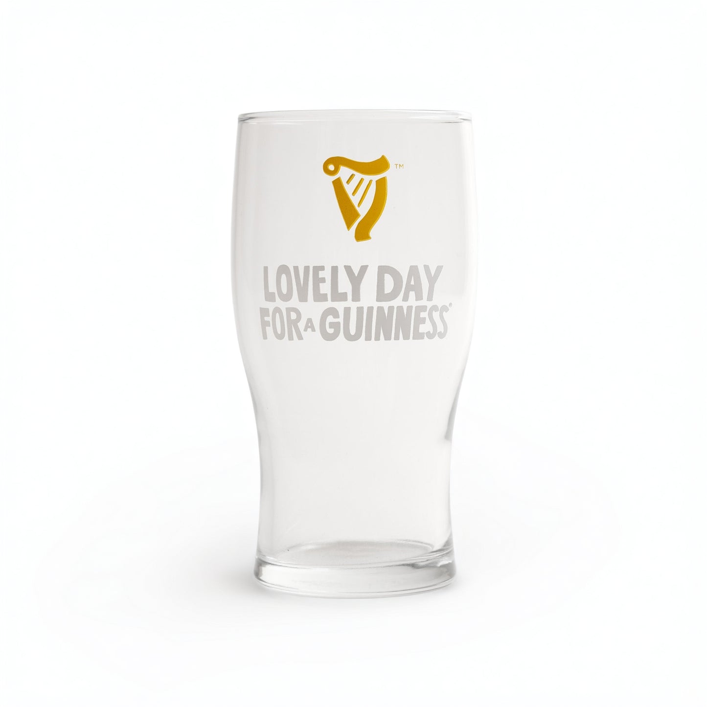 The Guinness Seb Curi Lovely Day Pint Glass from Guinness Webstore US features a gold harp logo above “Lovely Day for a Guinness” in white and gold, making it a perfect collector’s item for fans.