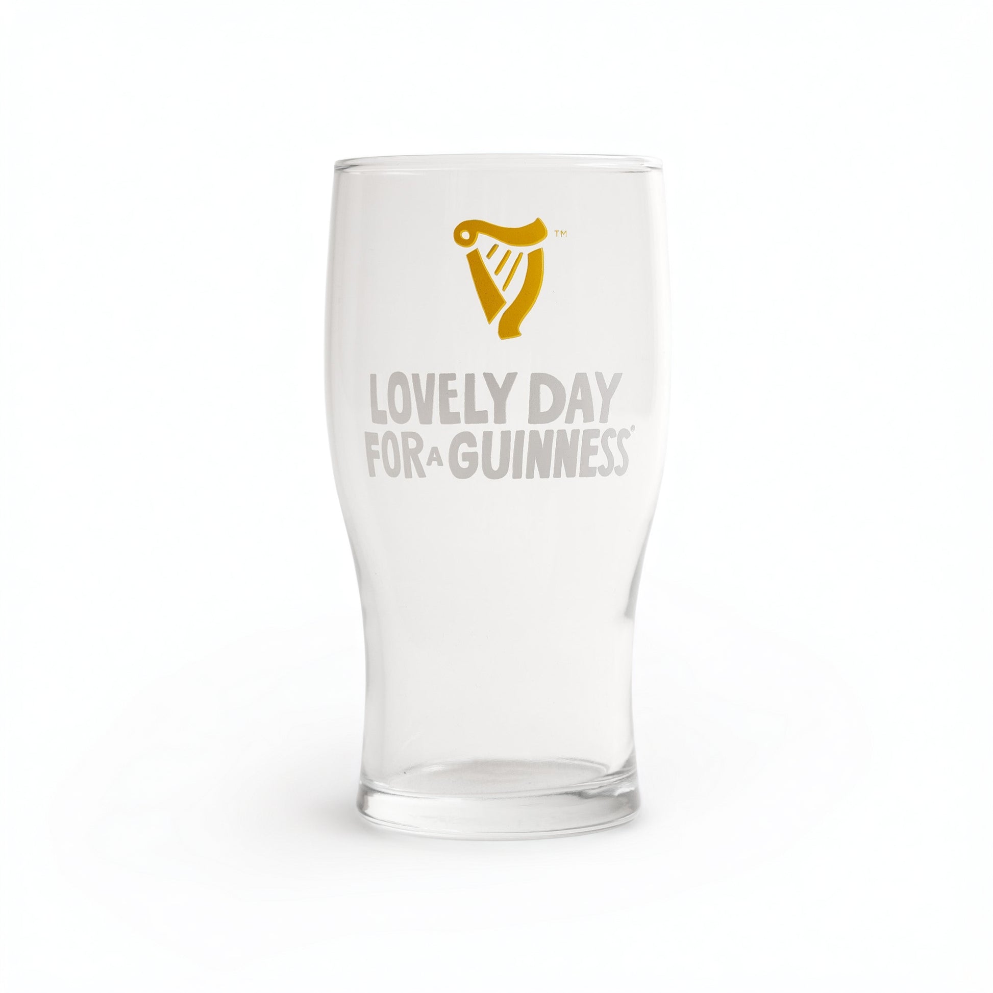 The Guinness Seb Curi Lovely Day Pint Glass from Guinness Webstore US features a gold harp logo above “Lovely Day for a Guinness” in white and gold, making it a perfect collector’s item for fans.