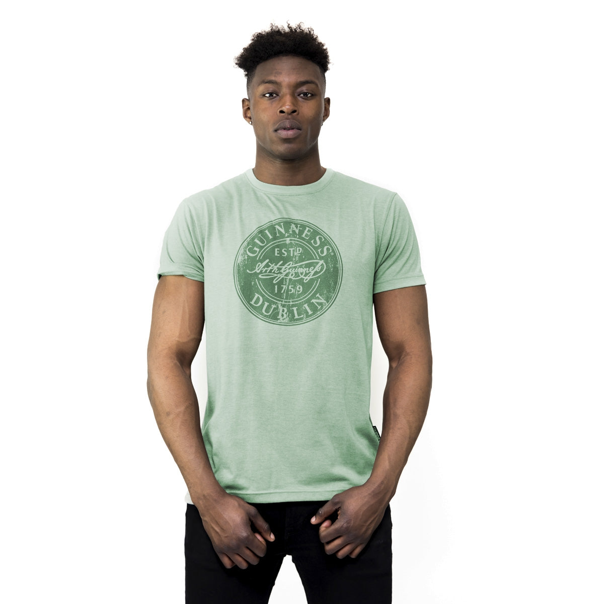 A man wearing a Guinness Green Bottle Cap Tee.