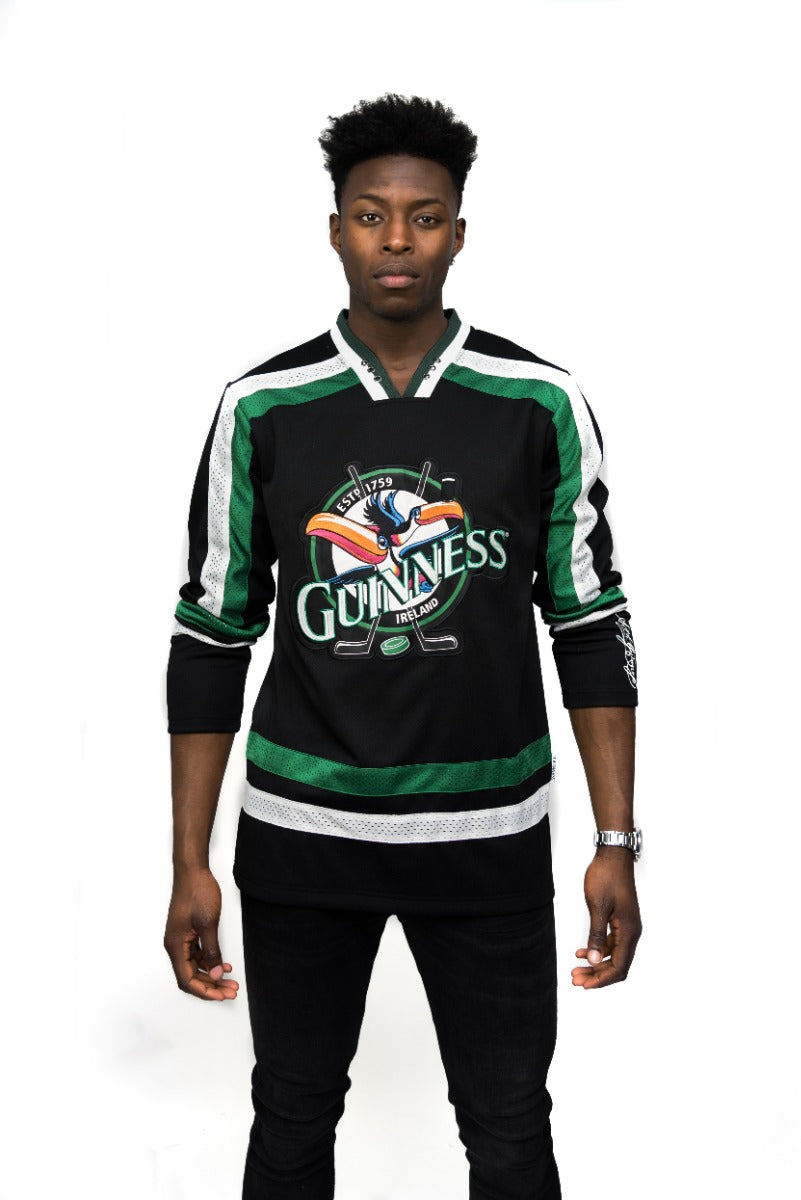 A man wearing a Guinness Toucan Hockey Jersey Black and Green.