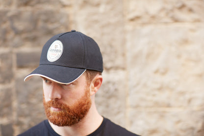 A Guinness fan with a red beard wearing a Guinness Label Baseball Cap.
