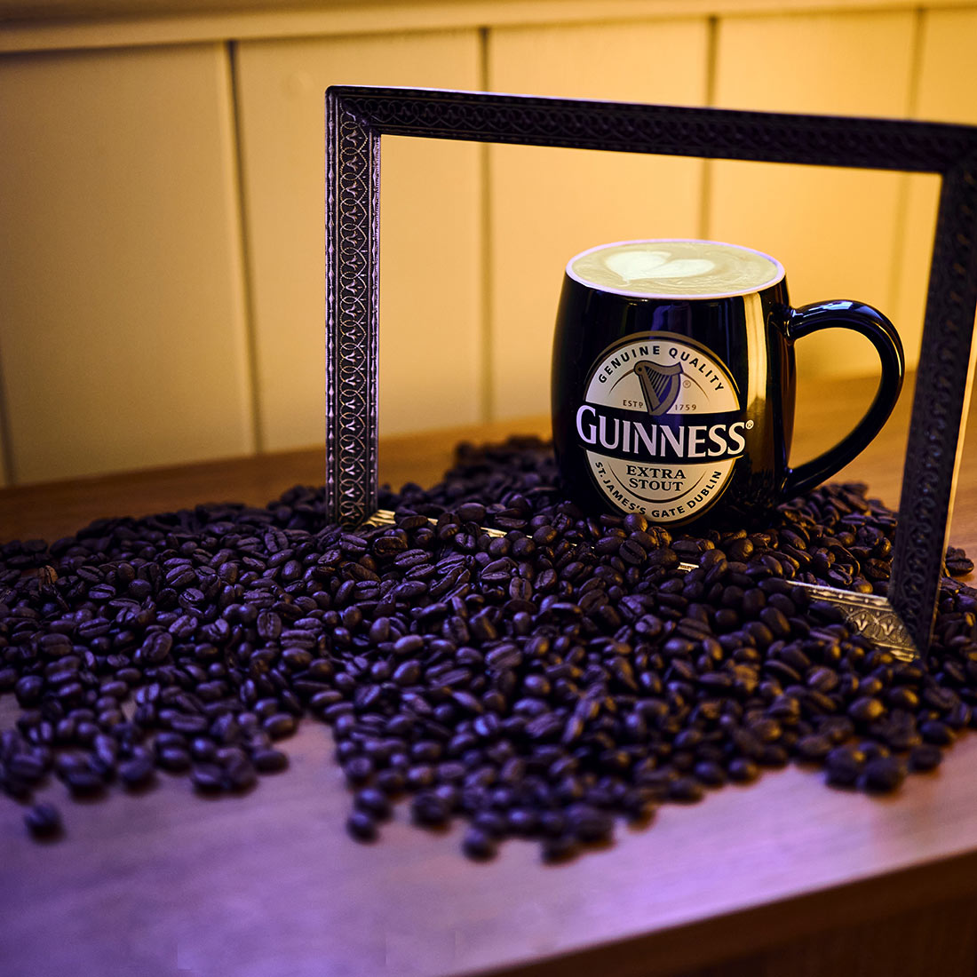 A Guinness coffee mug filled with freshly brewed Guinness Coffee Beans 227g on a table.
