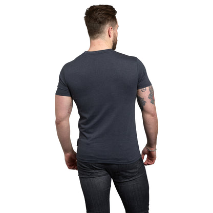 The back of a man wearing Guinness Navy Distressed Harp Tee and jeans.