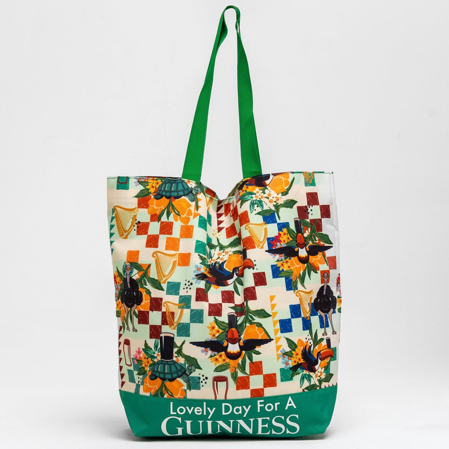 The Guinness Toucan Beach Bag from Guinness Webstore US features a vibrant patchwork of birds and harps, green handles, and "Lovely Day For A Guinness" text. With a spacious 20L capacity, it's perfect for carrying all your essentials.