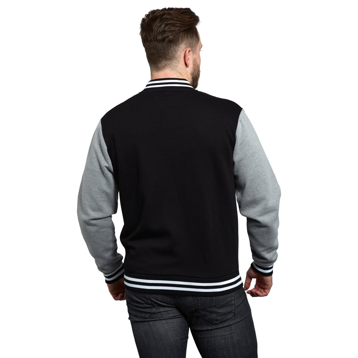 The back view of a man wearing a black and grey Guinness Letterman Jacket.