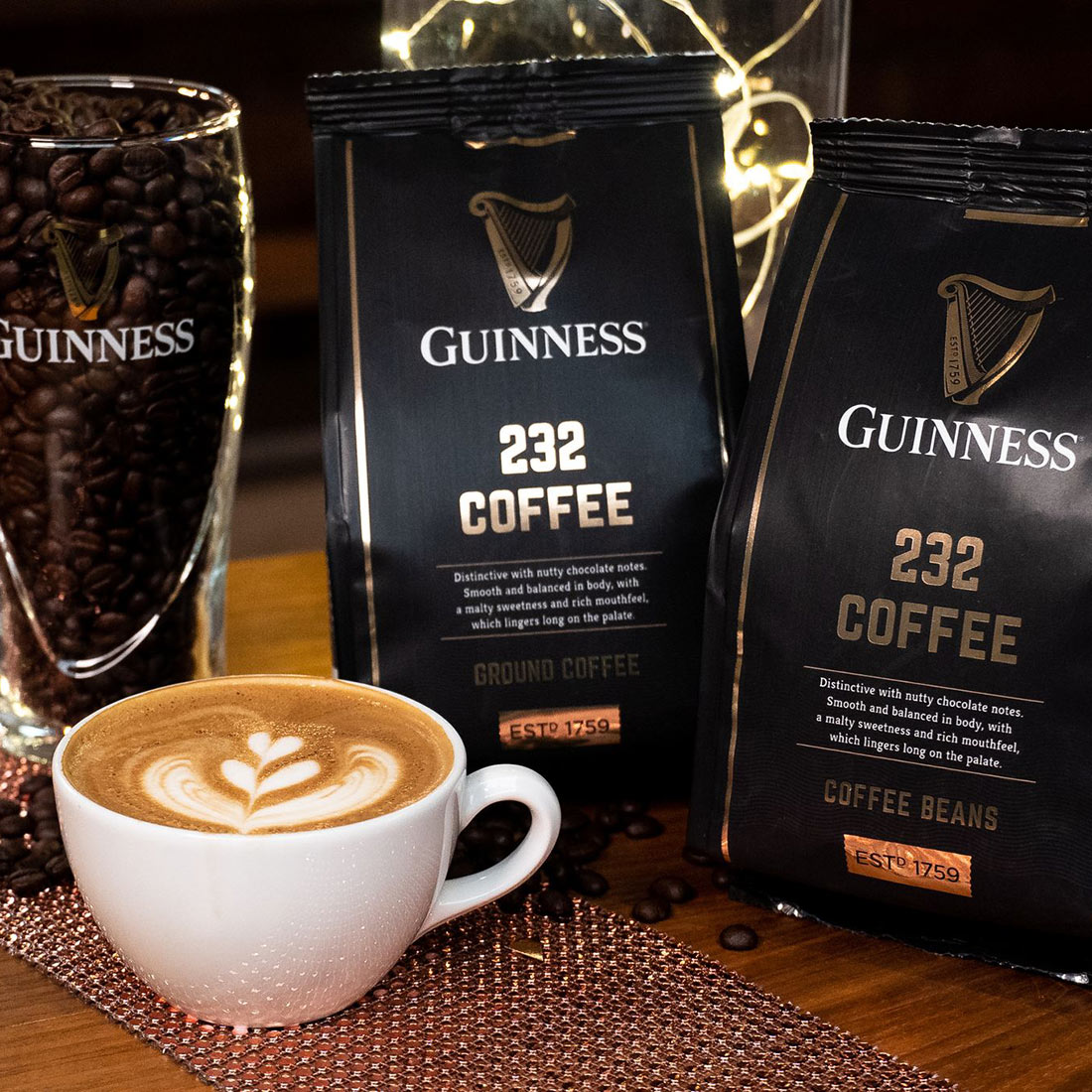 A table adorned with Guinness Coffee Beans 227g and a cup of coffee.