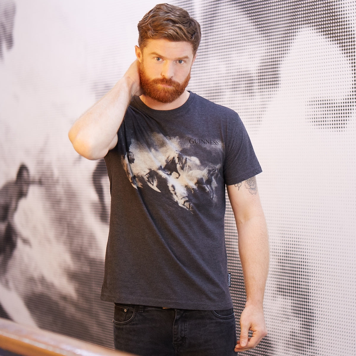 A man wearing a durable Guinness Surf Tee made of a cotton blend fabric.