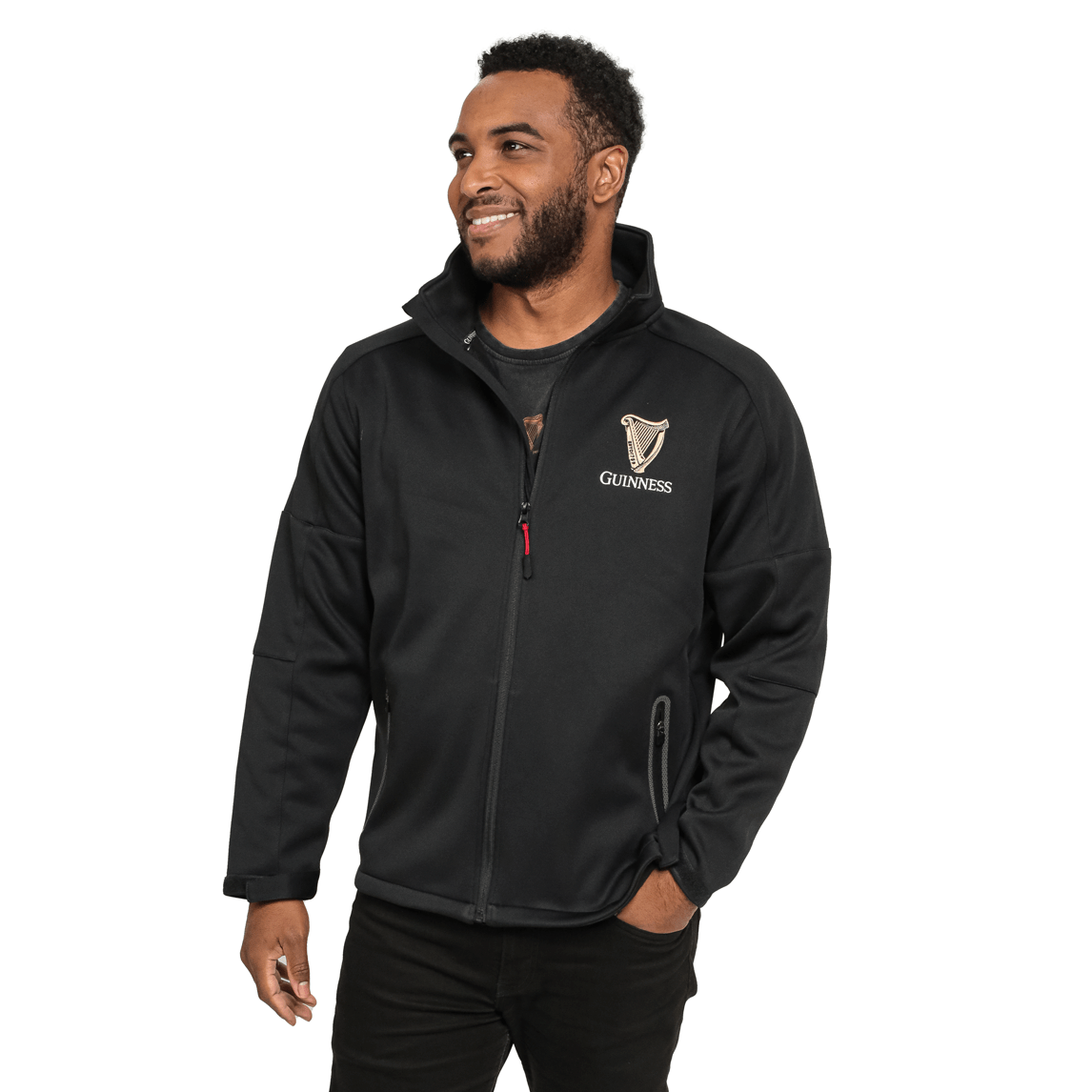 A man smiles while wearing the Guinness Soft Shell Waterproof Jacket, a black zip-up featuring the Guinness logo on the chest and a durable TPU coating.