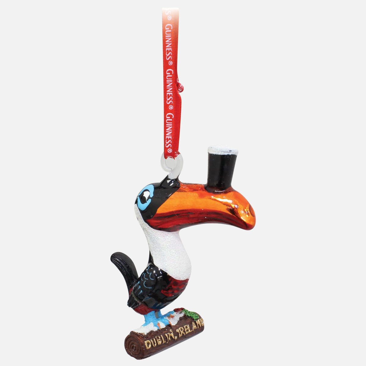Guinness® Toucan Hanging Decoration featuring a toucan balancing a glass of dark beer with a white head on its beak while standing on a branch labeled “Dublin, Ireland.”