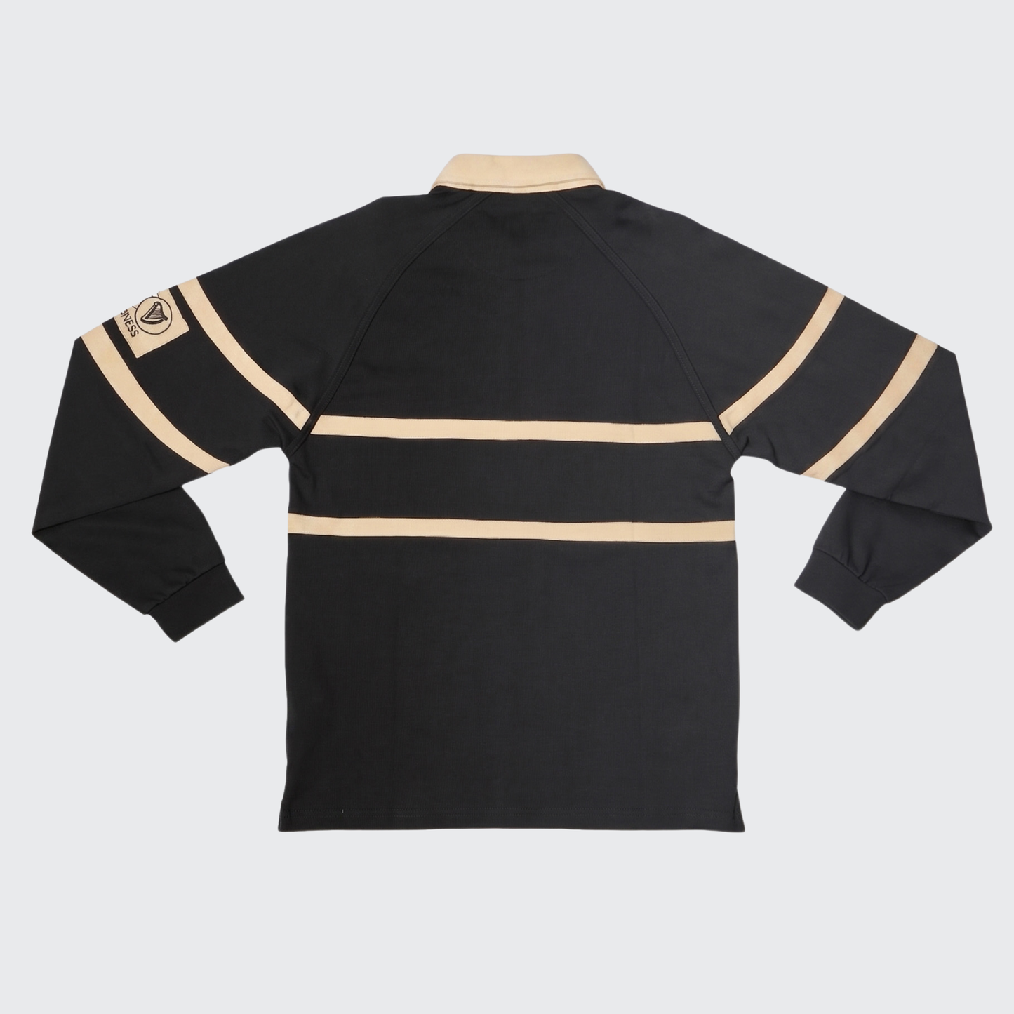 Here is a revised version of the sentence using your product data: The Guinness Black Traditional Rugby Jersey, made from 100% cotton, features long sleeves with two beige horizontal stripes and a beige collar, and is shown from the back. A beige patch on the upper left sleeve highlights the classic style of this rugby shirt by Guinness.