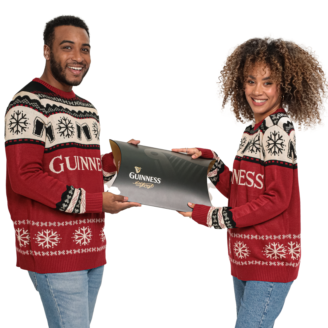 A man and a woman wearing matching Guinness apparel hold a large black Guinness Clothing Gift Box.