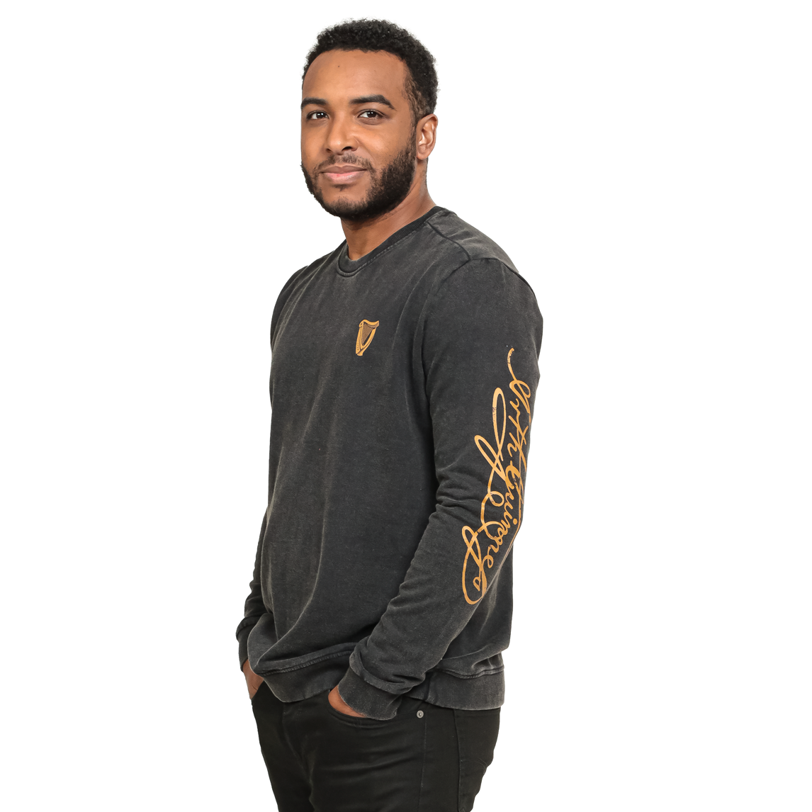 A man wears a black Guinness Gold Harp & Signature Distressed Sweatshirt featuring a gold harp logo on the chest and a gold signature down the left sleeve.