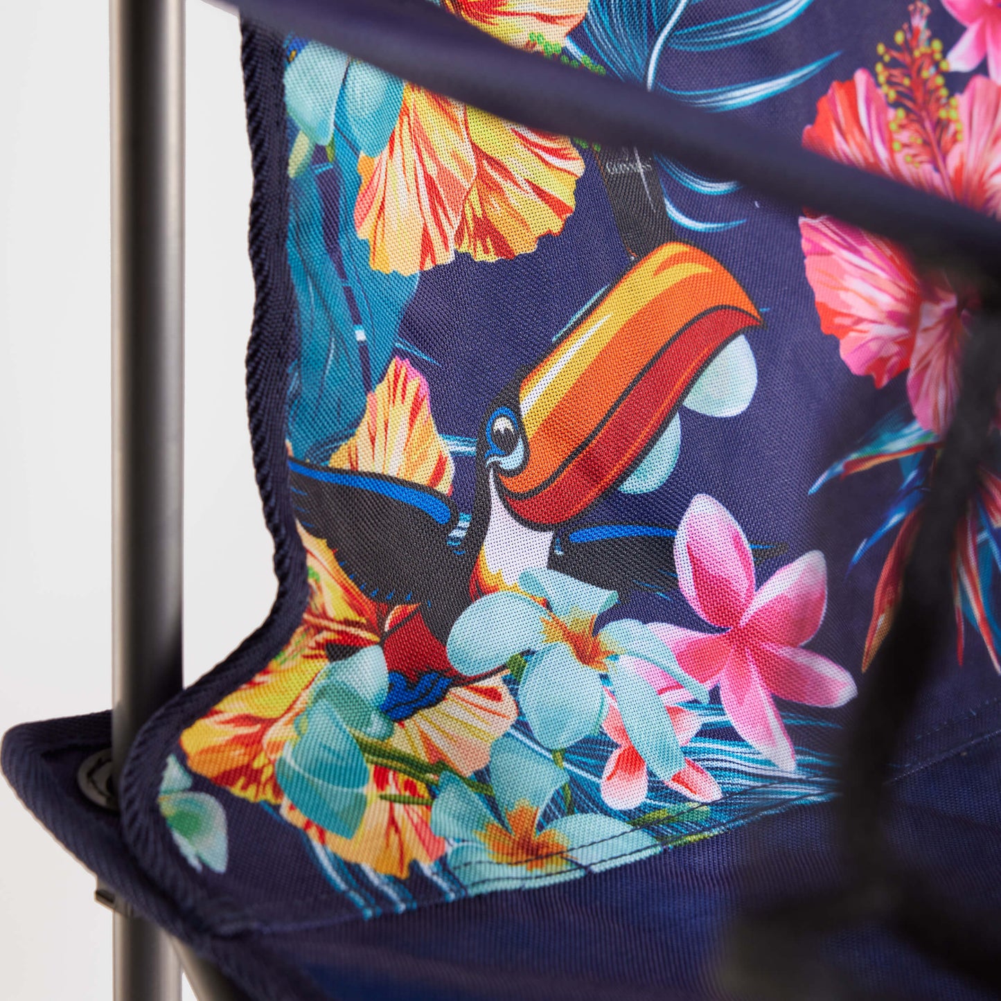 The Guinness Toucan Hawaiian Beach Chair from Guinness Webstore US features a vibrant blue tropical print with toucan artwork and a foldable design, making it an ideal beach essential.