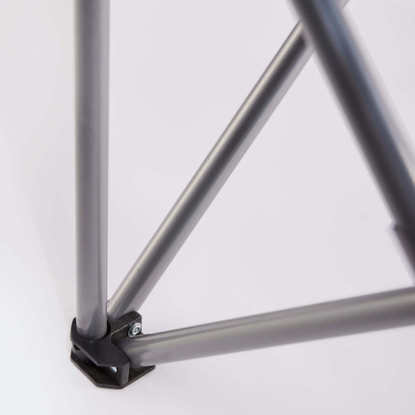 Close-up of intersecting metal rods forming a triangular structure, secured by a black plastic connector—echoing the durable frame of the Guinness Toucan Hawaiian Beach Chair from Guinness Webstore US—set against a white background.