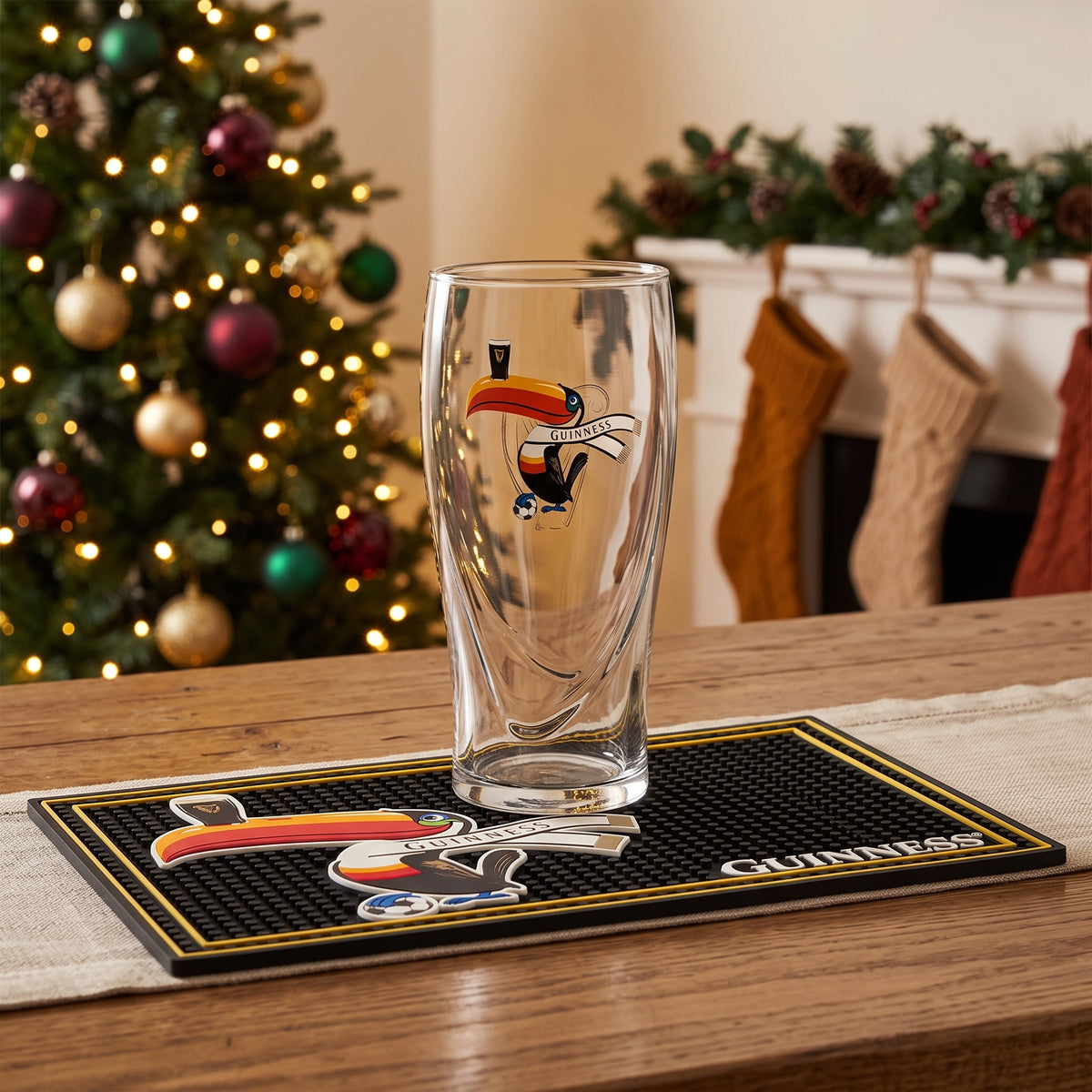 The Guinness Soccer Holiday Gift Set from Guinness Webstore US is the perfect soccer gift, featuring a toucan glass and bar mat amid festive Christmas decor.