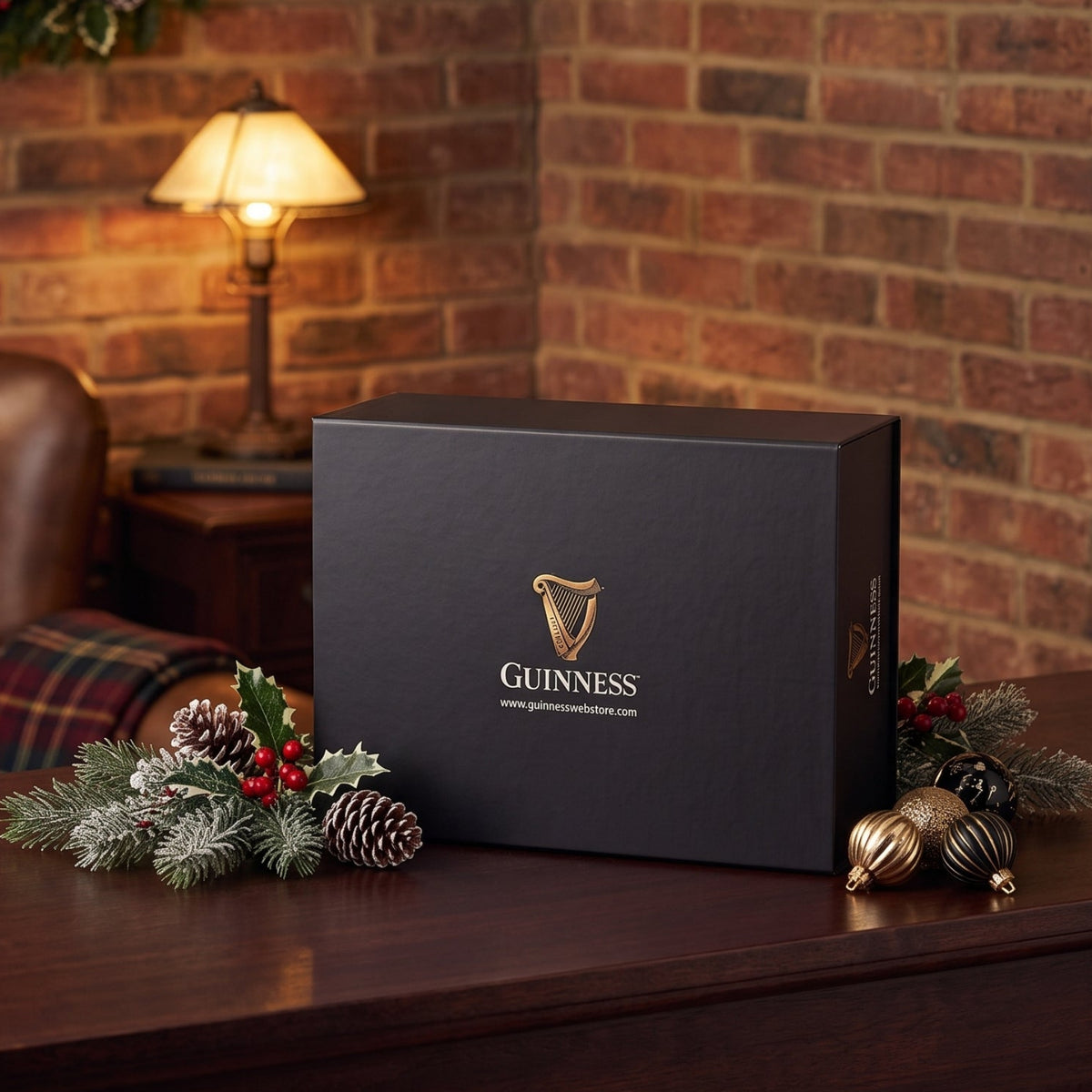 A Guinness Gift Box - Large sits on a wooden desk with Christmas decorations, making it a perfect Guinness gift or collector’s edition.