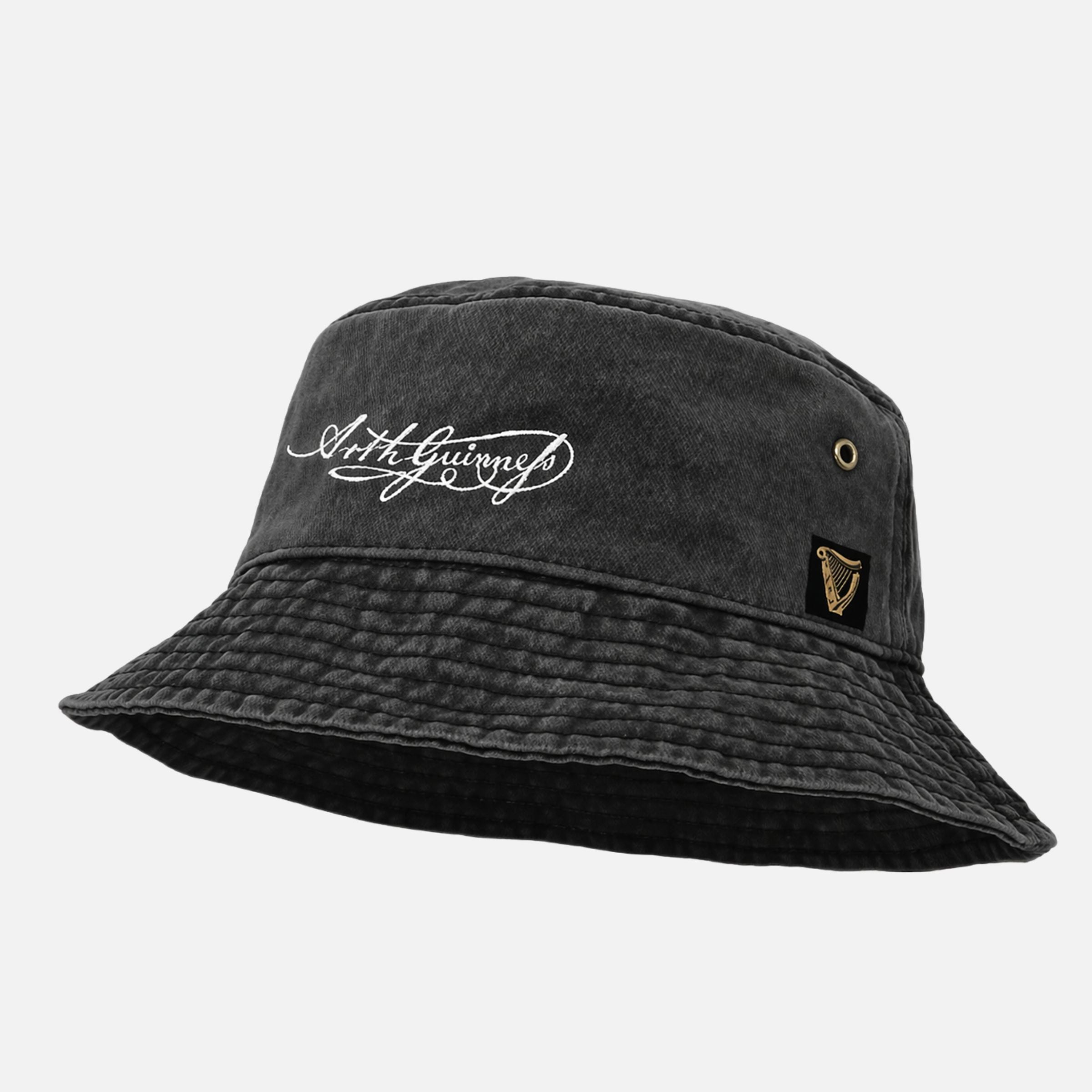 The Guinness Signature Bucket Hat is a black hat with white "Arthur Guinness" cursive text signature and a gold harp logo patch on the side—an ideal gift for any Guinness fan.