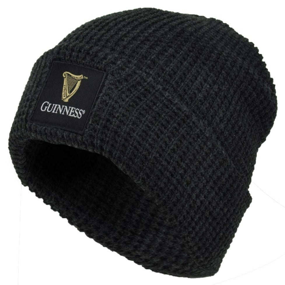 The Guinness Thermal Warm Beanie is a black knit hat with a rectangular patch featuring the Guinness logo and harp on the front. This cozy, unisex beanie keeps you warm and is perfect for any fan of the iconic Guinness brand.