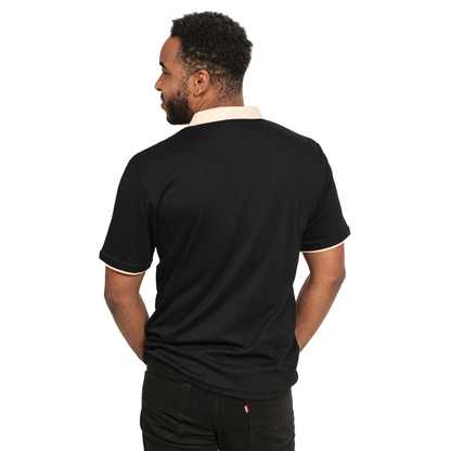 The back view of a man wearing a Guinness Black and White Traditional Short Sleeve Rugby shirt.