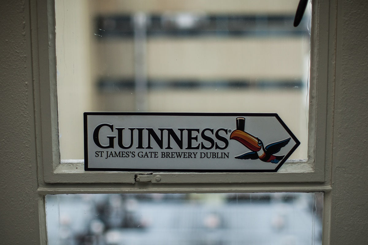 Wall art featuring a St James Gate Road Sign with the Guinness brand in a window.