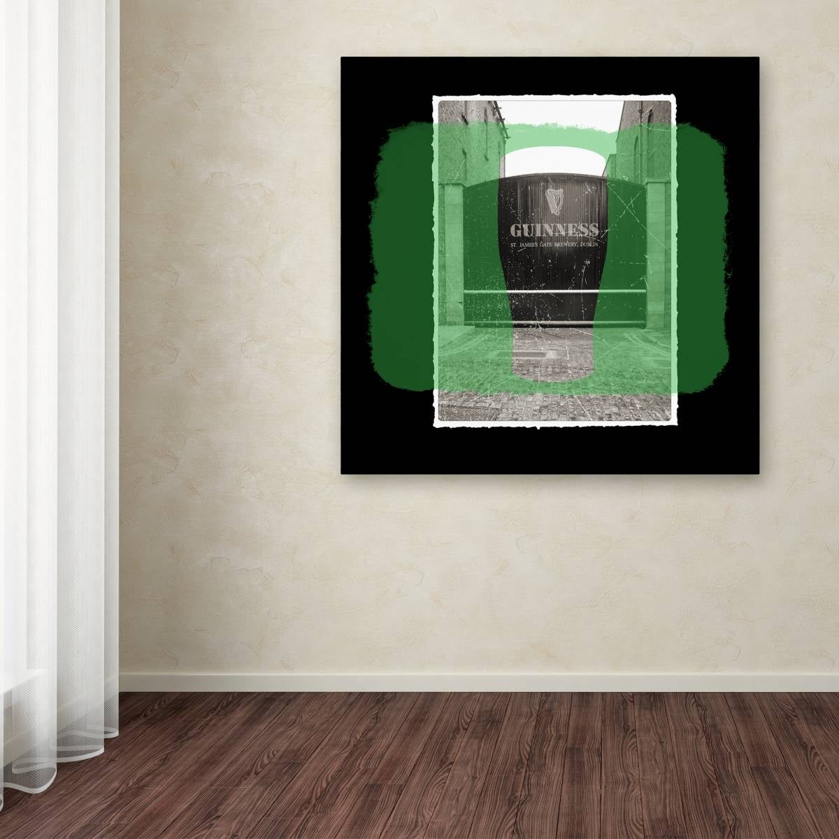 A Guinness Brewery 'Guinness XIV' canvas art portraying a black and green painting on a wall in a room.
