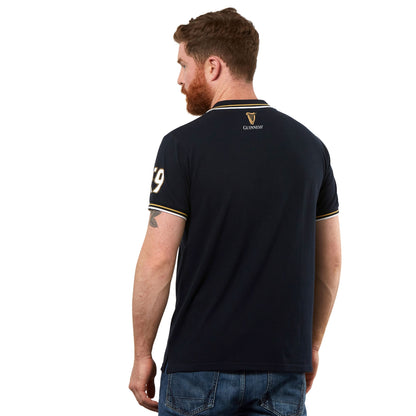 The back view of a man wearing a navy Guinness Black Pique Polo Shirt.