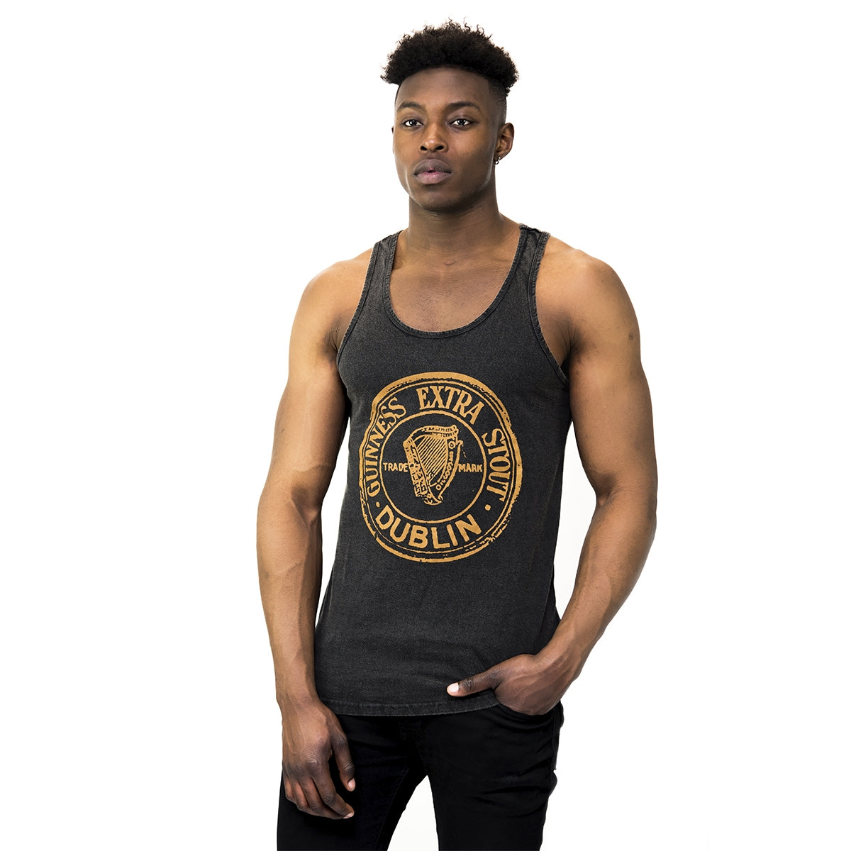 A man wearing a Guinness Washed Extra Stout Tank Top, perfect for the summer months.