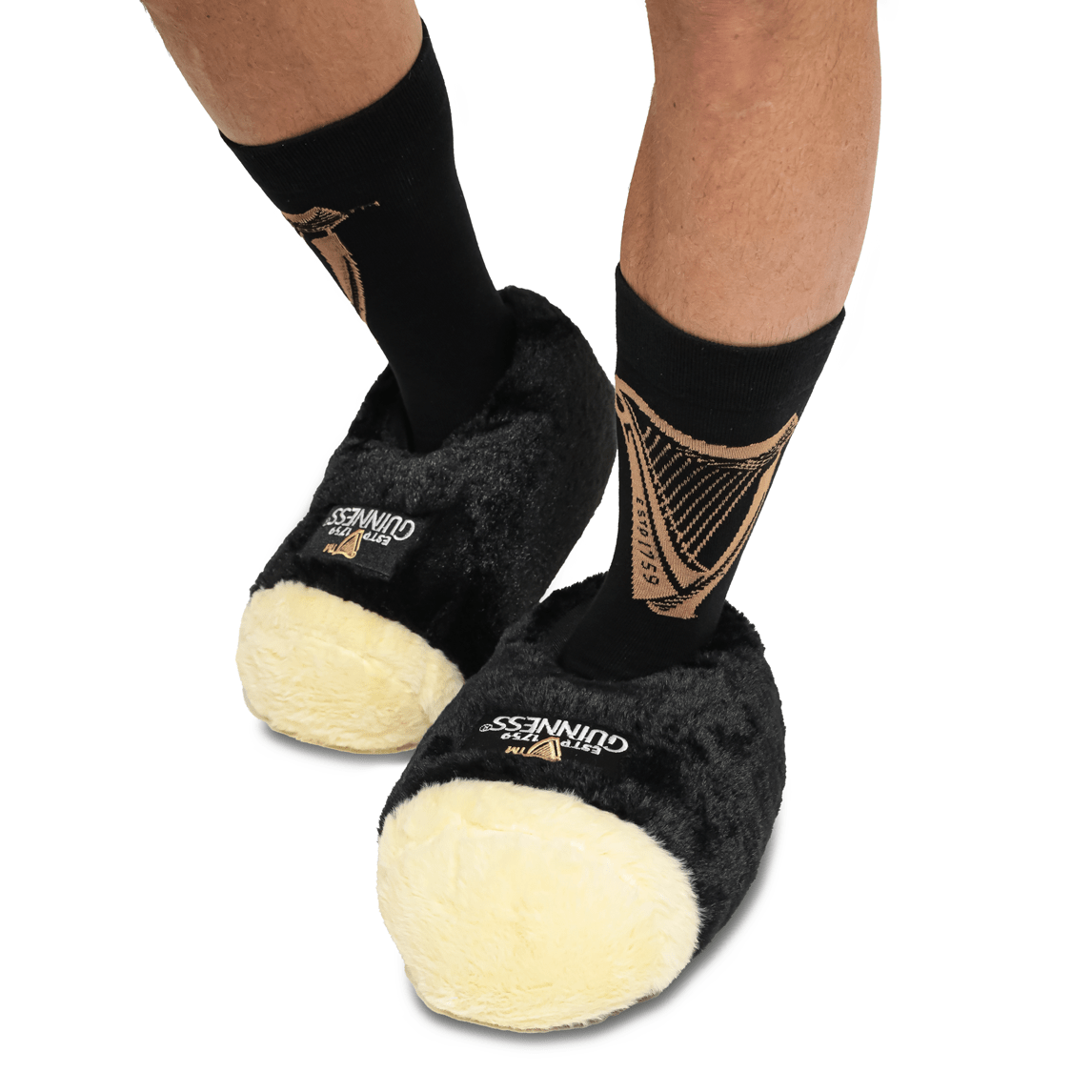 A man sporting a pair of classic Guinness® Pint Slippers adorned in the trademark Guinness logo.