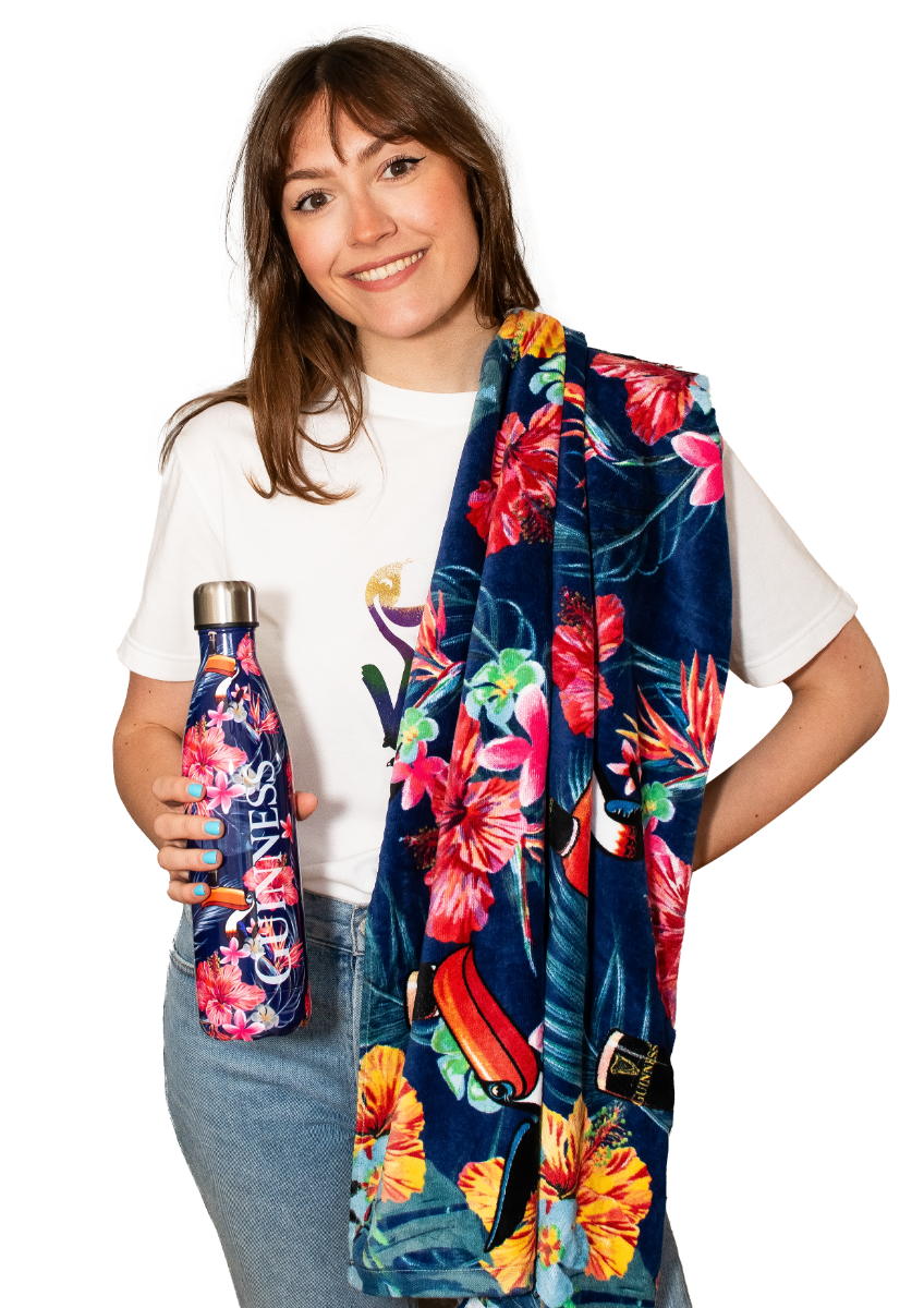 A woman holding a Guinness Toucan Hawaiian Beach Towel.