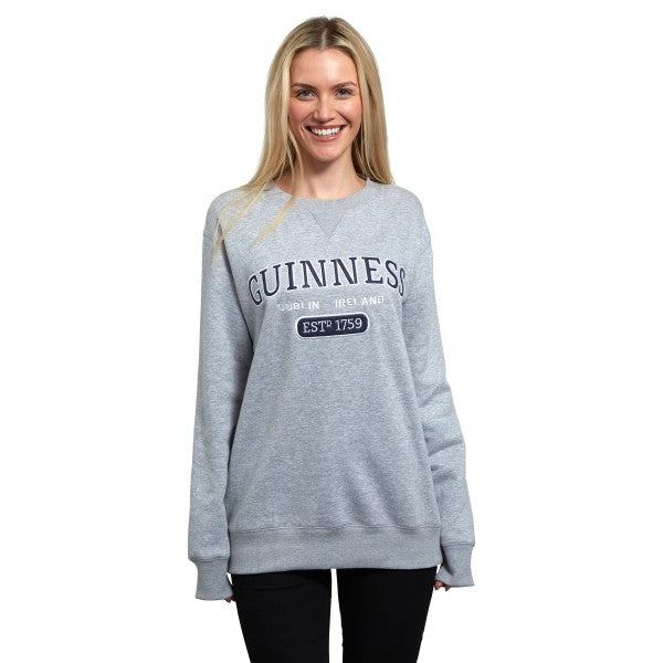 A woman wearing a Guinness Grey Crew Neck Sweatshirt.