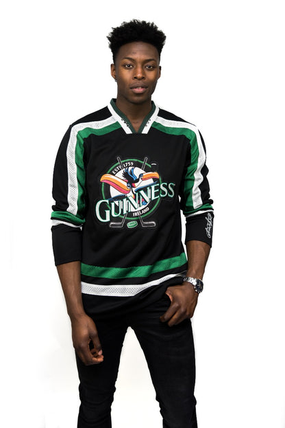 A man wearing a Guinness Toucan Hockey Jersey Black and Green.