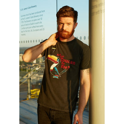 A man wearing a Guinness Are you Toucan to me Tee, made of 100% cotton.