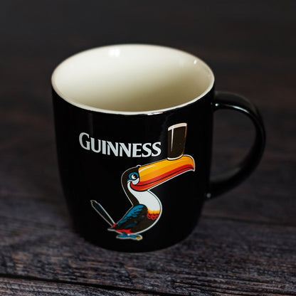 A Guinness Black Mug with Standing Toucan adorned with a vibrant toucan.