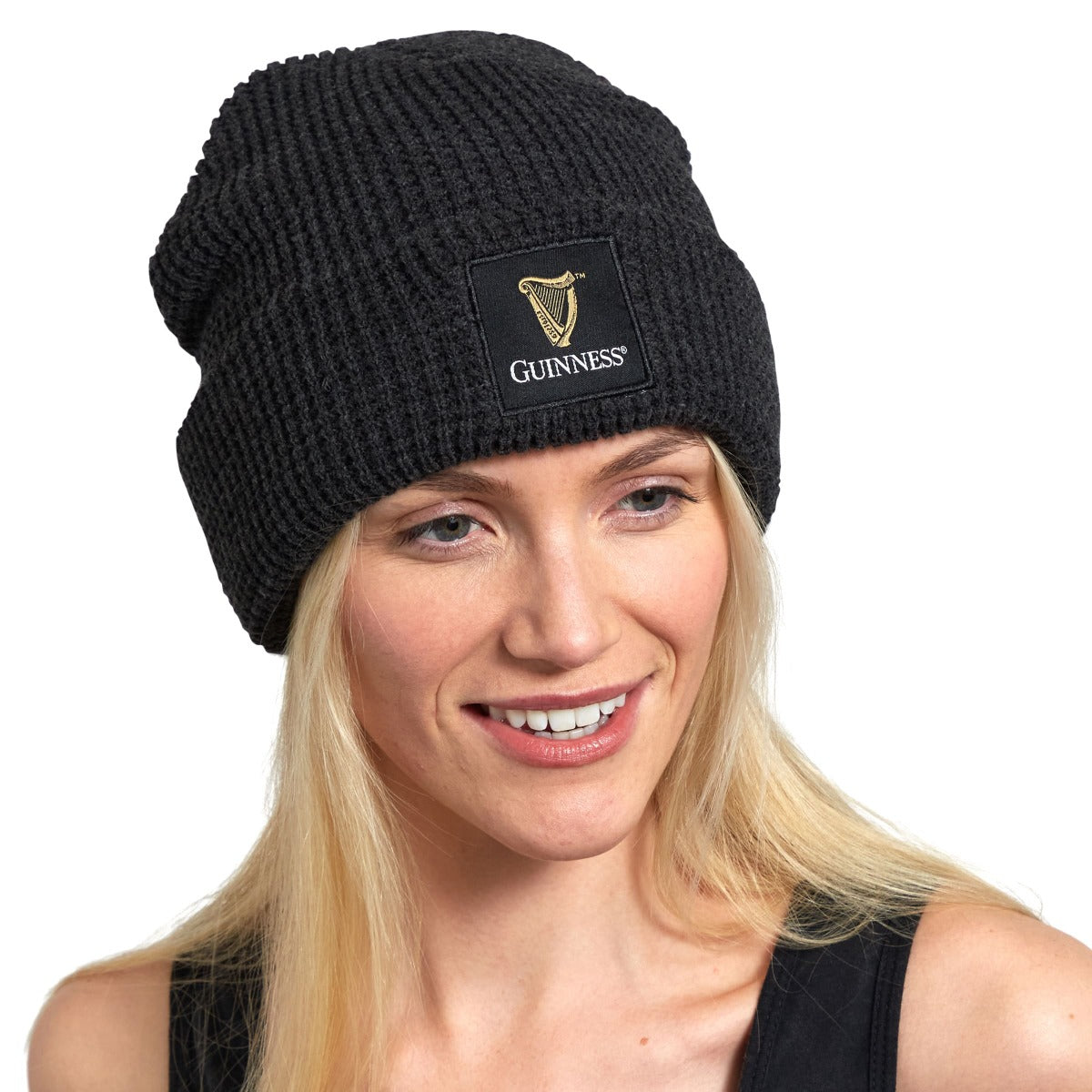 A woman wearing a Guinness Thinsulated beanie, with the Guinness logo showcased prominently on it.