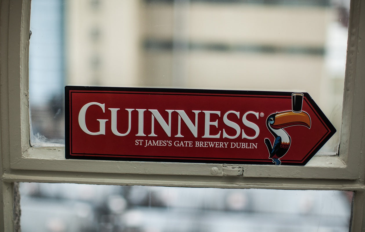 Red Toucan Pint Road Sign Guinness on a window sill.