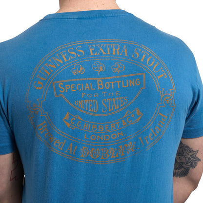 The back of a man wearing a blue Guinness Trademark Label T-Shirt.