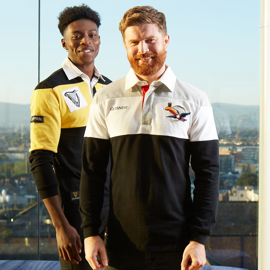 Two men wearing Guinness Toucan Rugby Jerseys standing next to each other.