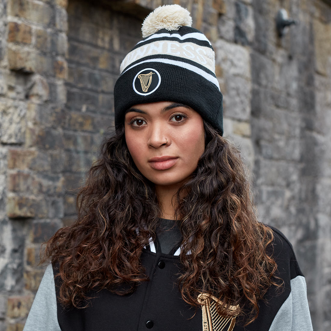 A cozy young woman wearing a warm Guinness Black and White Premium Beanie.