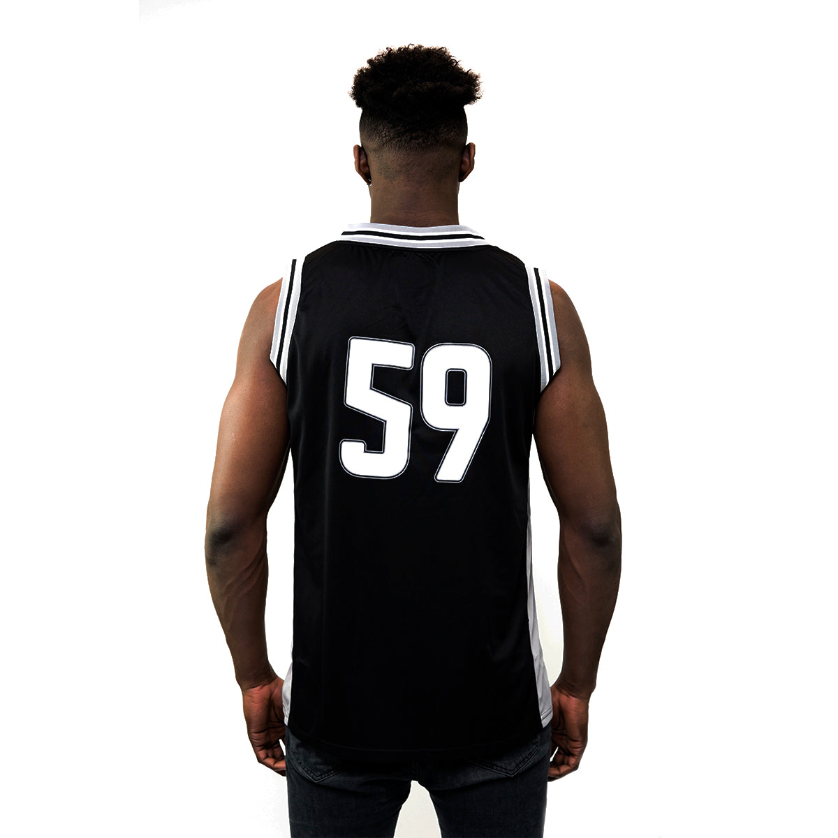 A person stands facing away wearing the sleek black Guinness Black & Grey Basketball Jersey, numbered 1759, reminiscent of classic soccer fan apparel. Available on the Guinness Webstore US.