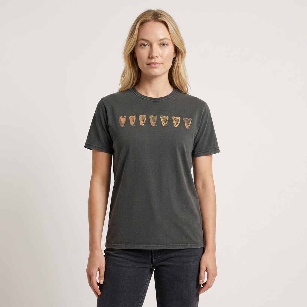 A woman stands facing forward, wearing the Guinness Black Evolution Harp Premium Tee—a dark shirt with five brown shield-shaped designs across the chest.