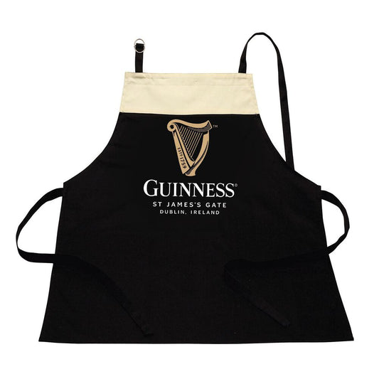 The Guinness Pint Apron, crafted from 100% cotton, showcases a black and beige design with the iconic Guinness harp logo. It features the text "Guinness, St James's Gate, Dublin, Ireland," making it an ideal accessory for handling kitchen spills with both ease and style.