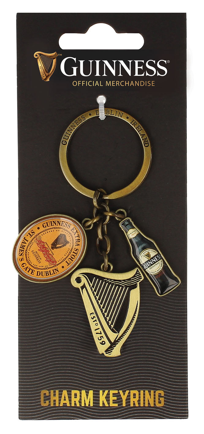 The Guinness US Charm Keyring - Harp includes three unique Guinness charms—a harp, a bottle, and a medallion—presented on official branded packaging.