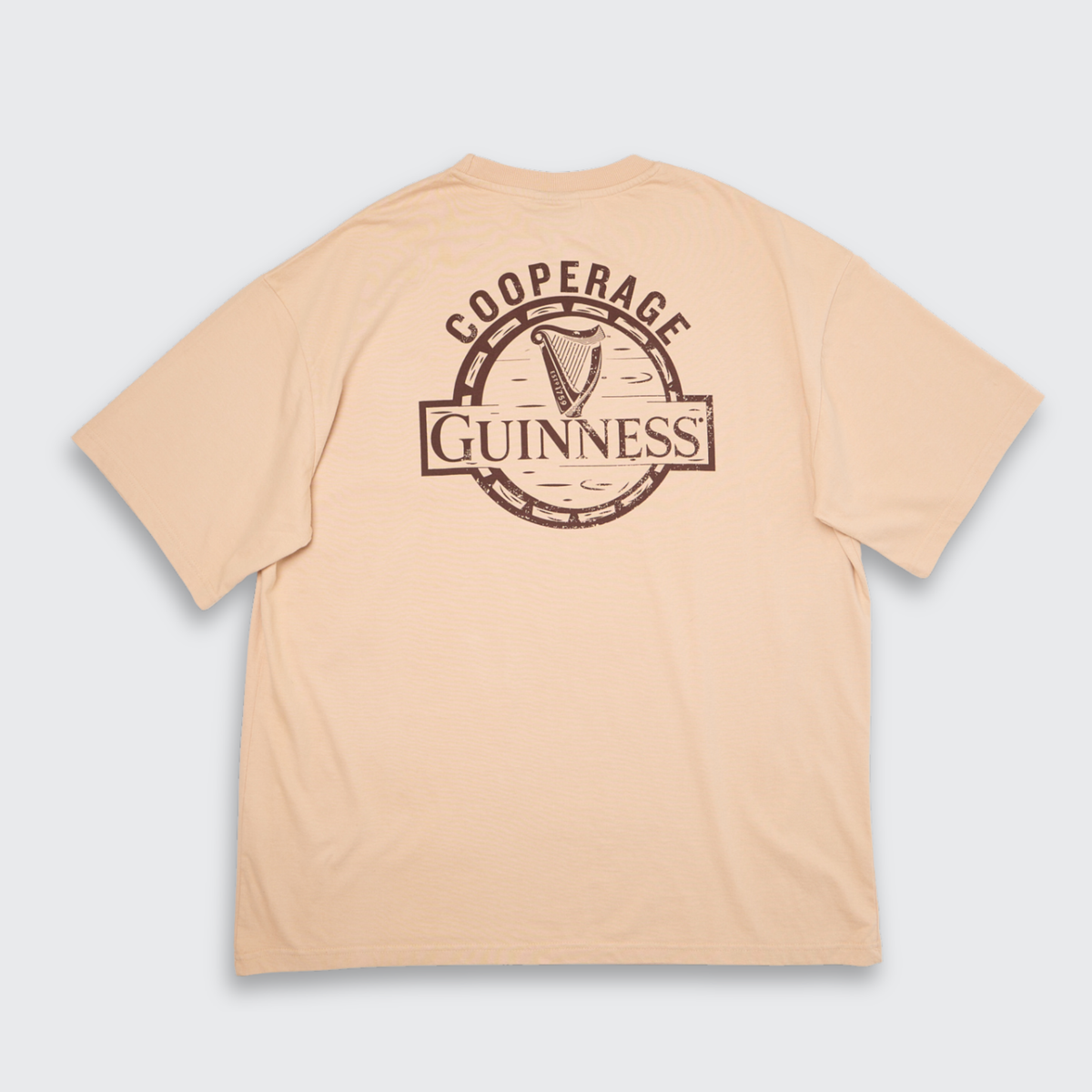 Guinness Cooperage Ivory Heavyweight Tee: oversized fit with “Guinness Cooperage” logo and harp in a brown circular back print. Brand: Guinness Webstore US.