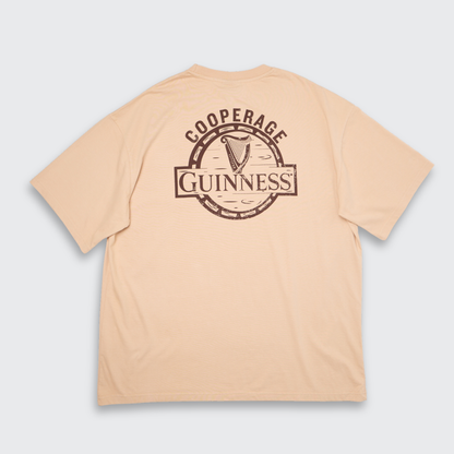 Guinness Cooperage Ivory Heavyweight Tee: oversized fit with “Guinness Cooperage” logo and harp in a brown circular back print. Brand: Guinness Webstore US.