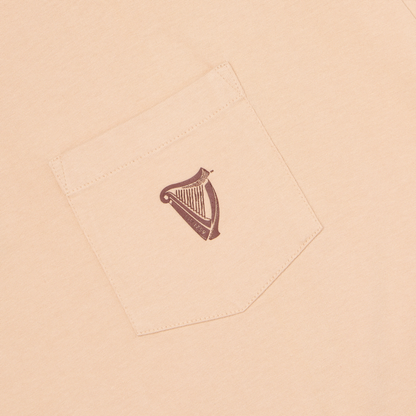 The Guinness Cooperage Ivory Heavyweight Tee features a beige fabric breast pocket with a small dark brown harp logo and “ESTD 1759” text.